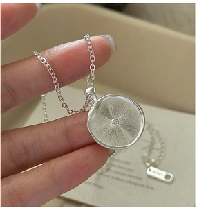 Makro-Detail einer S925 Sterlingsilber-Halskette mit Sonnenstrahl-Anhänger und Ag925-Stempel