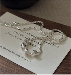Macro detail of S925 sterling silver popcorn chain necklace with five polished beads