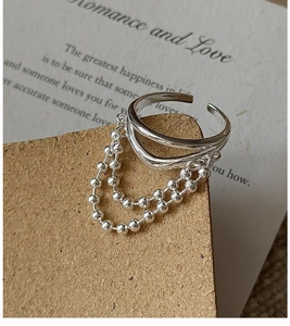 Detail of adjustable S925 sterling silver multilayer ring with hanging double bead chains