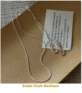 Detail of S925 sterling silver snake bone necklace with clasp on textured background