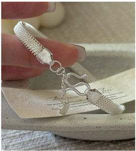 Macro detail of S925 silver mesh bracelet with intricate engraving and S-hook clasp