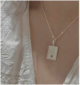 Detail of S925 silver necklace with Best Luck pendant and red heart stone