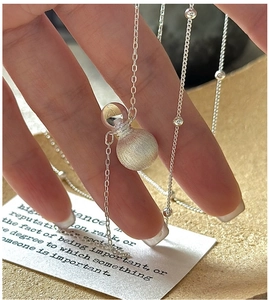 Close-up of S925 silver necklace featuring a dual-texture brushed and polished sphere charm