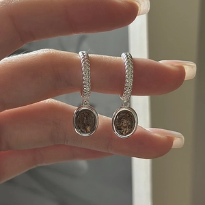 S925 sterling silver oval brown crystal earrings with textured silver hoops held in hand