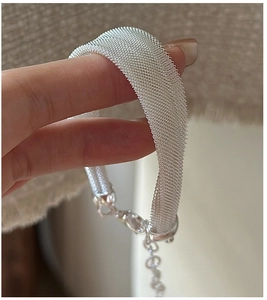 Detailed macro view of S925 sterling silver woven mesh bracelet with adjustable lobster clasp