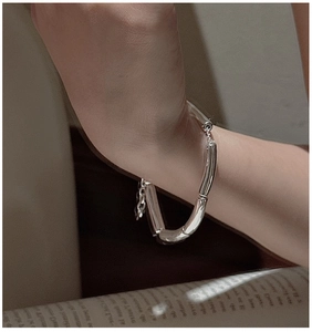 Detail of S925 silver minimalist bamboo-shaped jointed bracelet on wrist