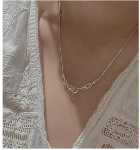 Detail of S925 sterling silver twisted knot pendant necklace worn on a lace collar