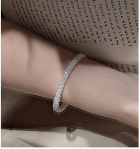 Macro detail of silver mesh texture on a minimalist S925 sterling silver cuff bracelet