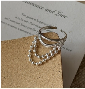 Detail shot of a silver S925 double-layer open ring with three hanging bead tassel chains