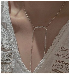 Close-up of S925 sterling silver Y-shaped drop necklace on neck with lace background