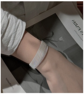 Detail view of a vintage S925 sterling silver mesh bracelet on a female wrist in style