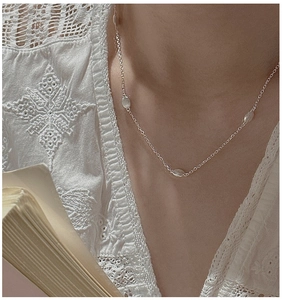 Close-up of S925 sterling silver necklace with textured bean charms on a model