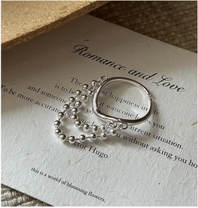 Macro shot of S925 sterling silver ring with delicate fringe chains on textured card