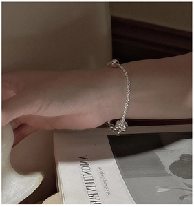 Detail of S925 sterling silver clover bracelet with tiny beads on a stylish chain