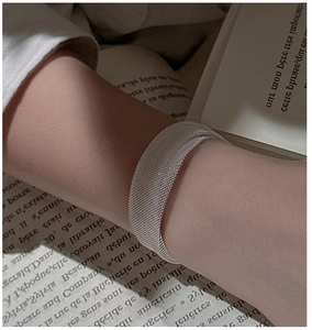 Detailed macro view of an S925 sterling silver mesh bracelet on a French book background
