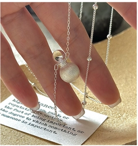 Macro detail of S925 sterling silver necklace with brushed finish spherical pendant