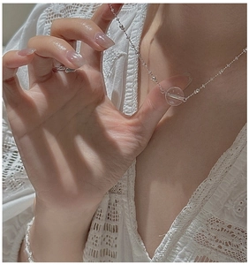Detailed close-up of a S925 silver necklace with a clear crystal bead on a model