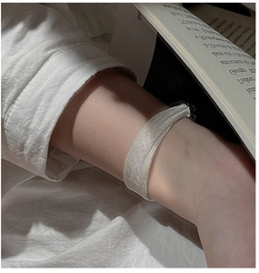 Detail of silver mesh bracelet showcasing the intricate woven texture and metallic luster