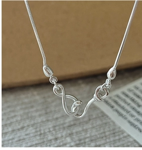Macro detail of S925 sterling silver infinity symbol clasp on a sleek snake chain necklace