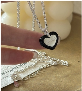 Macro du collier cœur en argent S925 avec émail noir et gravure 'grow' détaillée