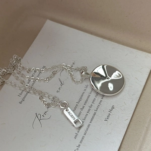 Minimalistische S925 Sterlingsilber Halskette mit gehämmertem Scheibenanhänger auf Papier