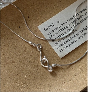 Macro shot of S925 silver snake chain necklace featuring a unique S-hook clasp detail