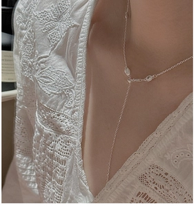 Detail of S925 sterling silver Y-shaped minimalist necklace worn on a model with lace top