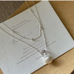 Detail of S925 sterling silver double layer necklace with brushed metal pendant and crystal