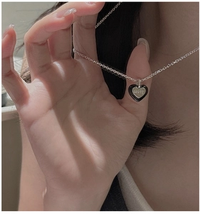 Gros plan du pendentif cœur en argent S925 avec émail noir et gravure LOVE