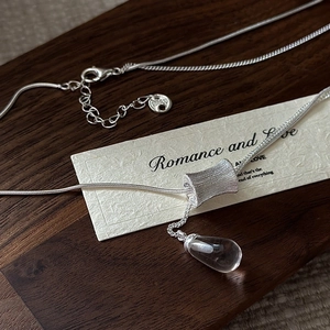 Collier en argent sterling S925 avec pendentif goutte d'eau sur fond bois sombre
