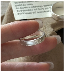 Macro detail of S925 sterling silver ring featuring irregular hammered texture and open band