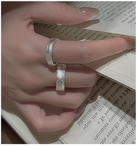 Detailed view of S925 sterling silver rings with unique lava texture on a book background