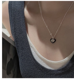 Détail du collier cœur en argent S925 avec émail noir et gravure LOVE sur mannequin