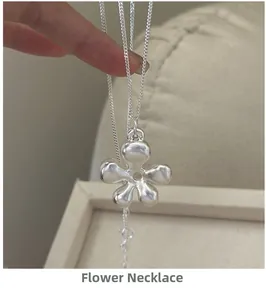 Detail of S925 sterling silver hollow flower pendant with matte finish on thin chain