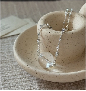 Macro detail of S925 sterling silver chain with a large clear crystal sphere pendant