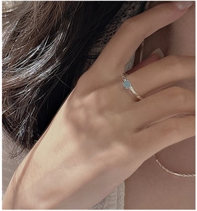 Detail of S925 sterling silver ring featuring a twisted band and blue aquamarine stone