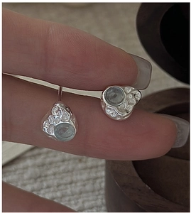 Macro shot of S925 silver earring featuring an aquamarine stone with irregular texture