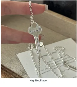 Close-up of S925 sterling silver key necklace with Love Me engraving and flower detail