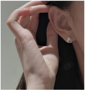 Close-up of S925 sterling silver earring with irregular liquid metal texture on ear