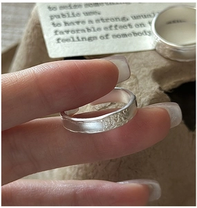 Macro view of wide silver ring featuring handcrafted hammered texture and matte finish