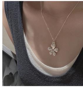 Detailed view of an S925 sterling silver hollow flower pendant on a slender chain