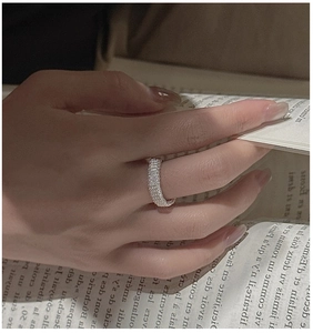 Détail de la texture tressée d'une bague en argent S925 sur fond de livre ouvert