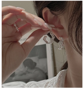 Detailed close-up of S925 sterling silver earrings with textured irregular wavy design