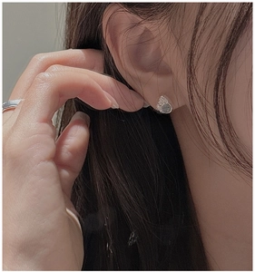 Close-up of minimalist S925 sterling silver stud earring with blue gemstone on ear