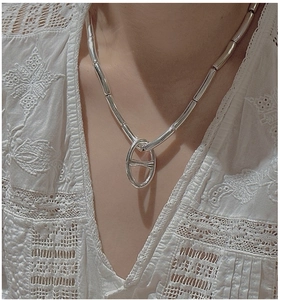 Detail of S925 sterling silver anchor link necklace worn on white lace blouse collar