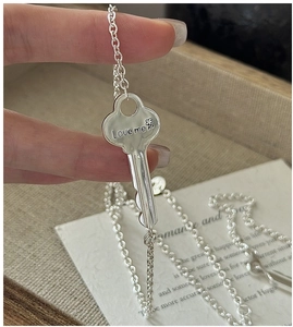 Close-up of S925 sterling silver key pendant featuring Love me engraving and delicate chain