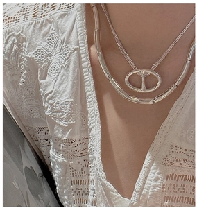 Detail of S925 sterling silver layered necklace set with pig nose pendant on lace clothing