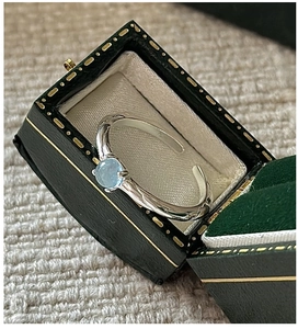 Macro detail of a vintage S925 silver aquamarine ring in a green velvet jewelry box