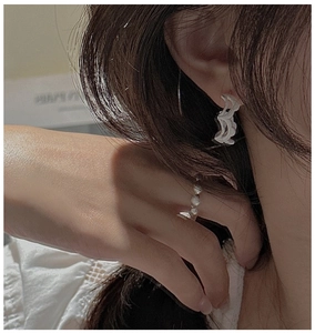 Macro detail of S925 sterling silver wavy textured earrings on a female model