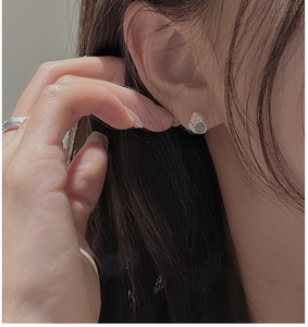 Close-up of S925 sterling silver cat claw earrings with blue gemstone on model